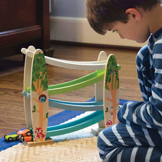 Wooden car ramp with four mini toy cars with painted tree and animal theme.