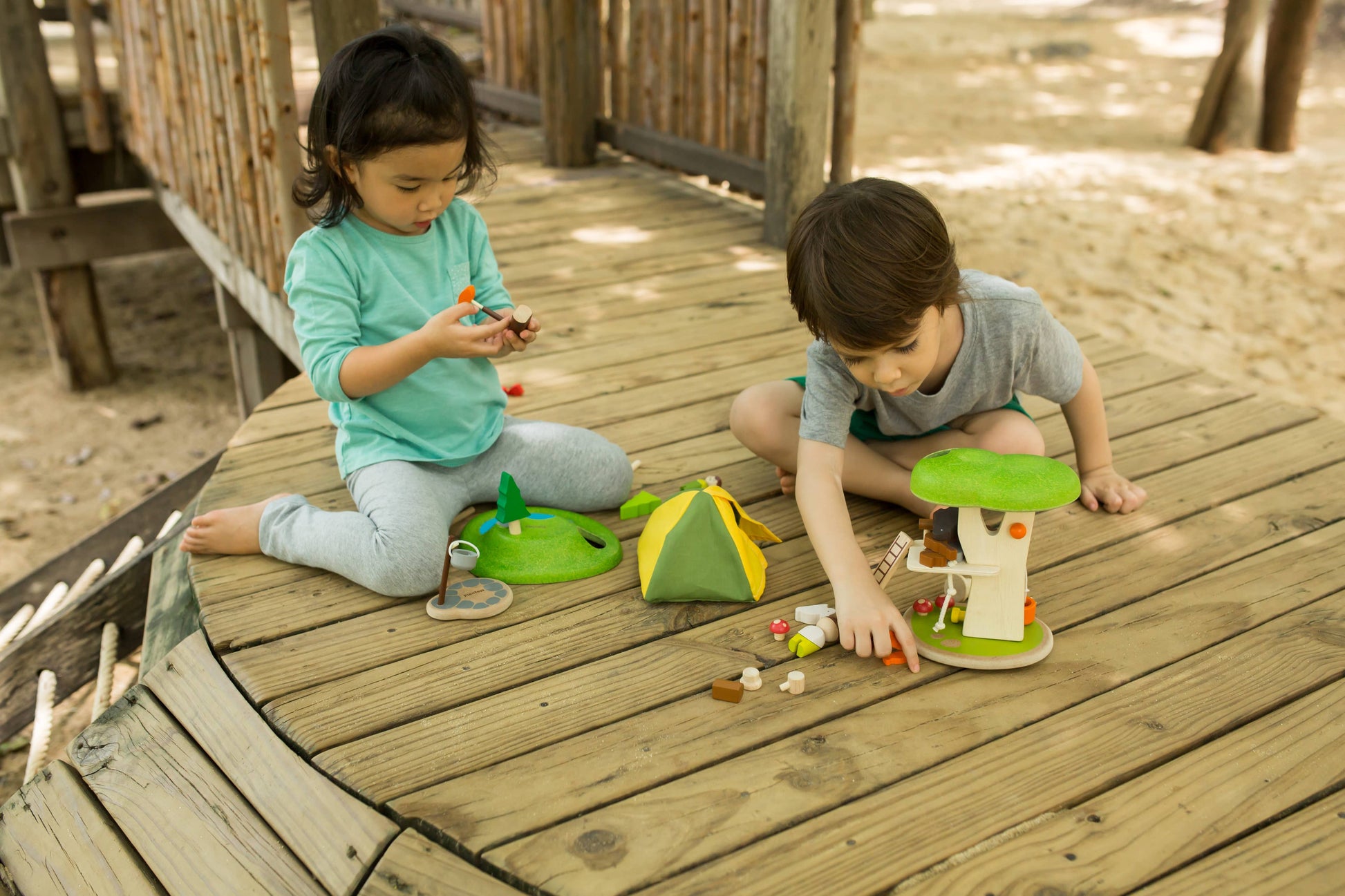 children playing outside with the treehouse playset with wooden figures