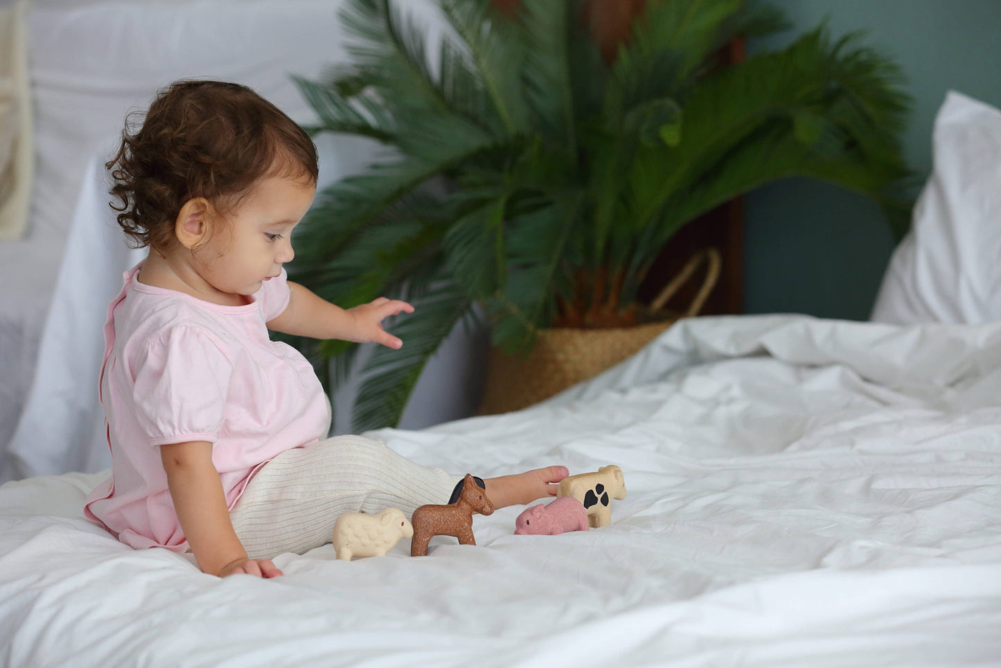 Little girl playing with farm animal figure set