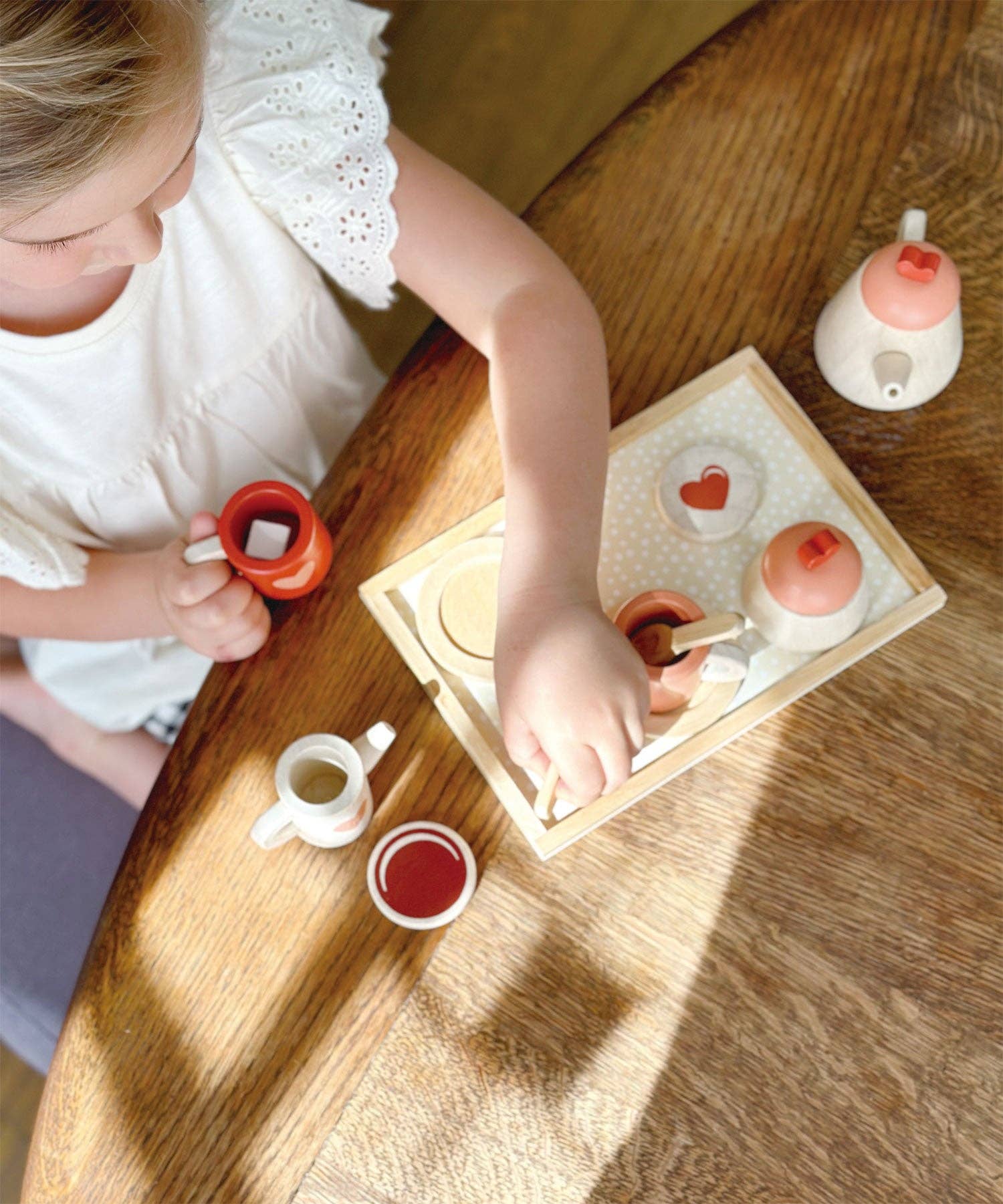 Mentari brand sustainable tea set is being played with at a tea party with a little girl.