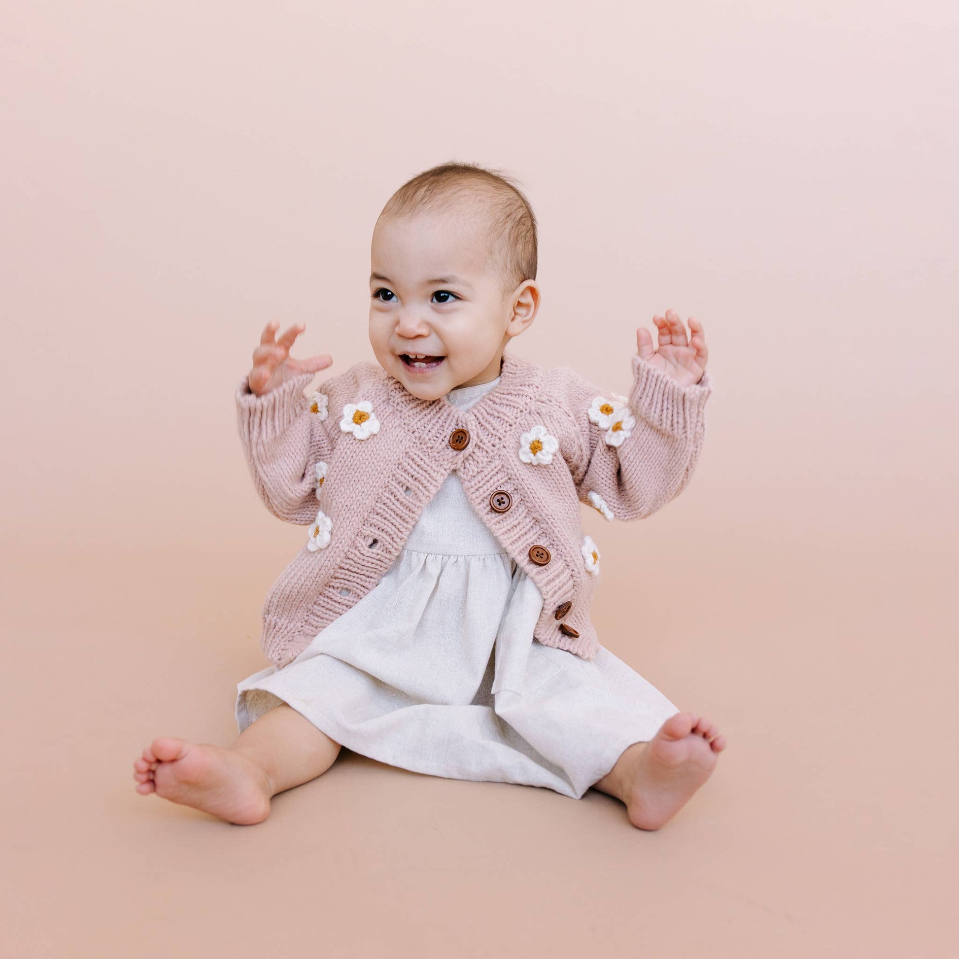 Pink cardigan sweater with knit 3D daisies for baby