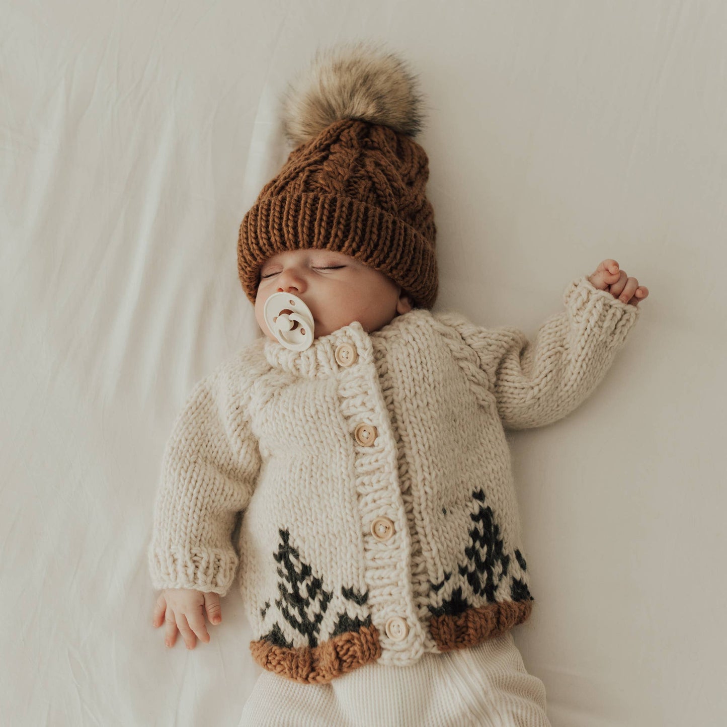 baby wearing handknit cardigan sweater with winter aesthetic